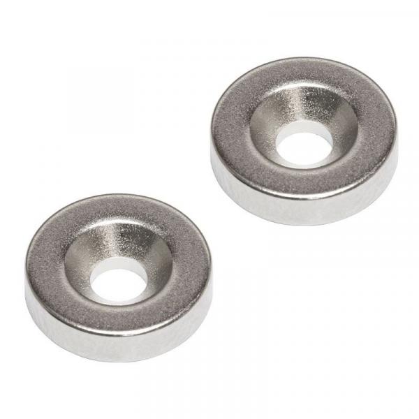 Das Bild zeigt zwei flache, runde Scheiben aus Metall mit einem zentralen Loch. Die Oberflächen sind glänzend und spiegeln Licht, der Rand ist leicht erhöht.