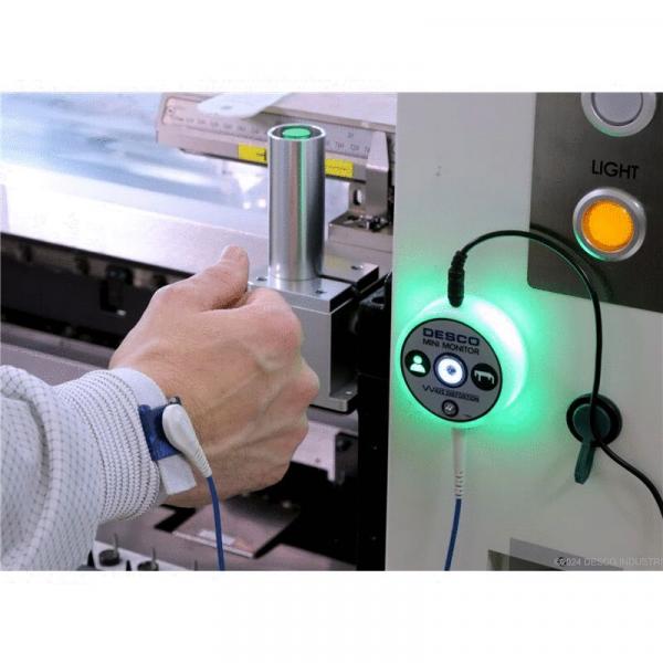 Das Bild zeigt eine Hand, die einen silbernen zylindrischen Gegenstand hält. Neben der Hand befindet sich ein Bedienfeld mit grüner LED-Anzeige und Tasten zur Steuerung.