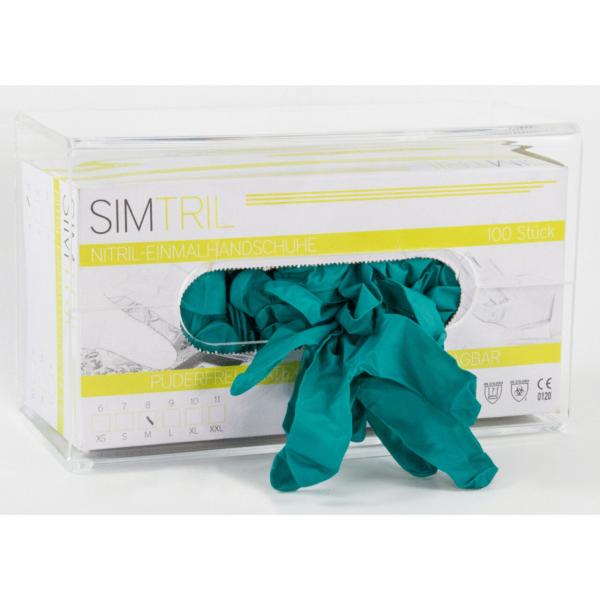 Das Bild zeigt eine transparente Kunststoffbox mit einer Öffnung. Darin sind mehrere teal-farbene Gummihandschuhe, die leicht zerknüllt herausragen. Die Box ist beschriftet.