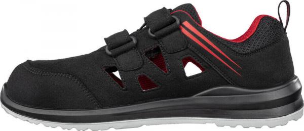 The image shows a black shoe that looks sporty and modern. It has two Velcro straps and side ventilation holes. The inside is red and the sole is sturdy and black.