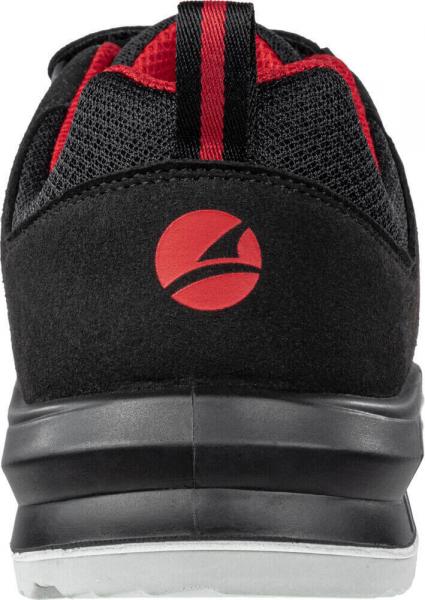 The image shows the rear view of a black sports shoe with red accents. It features a sturdy, slightly curved sole and a striking logo in the shape of a red circle.