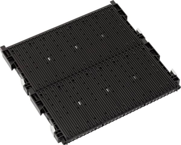 The image shows a black, flat plastic plate with several parallel grooves and recesses. It has fasteners at the corners and is rectangular in shape.