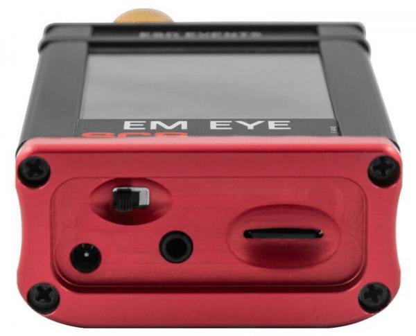 The image shows a small, rectangular device with a smooth surface. It has black and red colors, a top and a bottom side with several ports and switches. A display is visible.