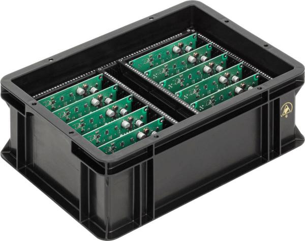 The image shows a black plastic box with two separate compartments. Each compartment contains green circuit boards equipped with small components. The box is sturdy and has a practical shape.