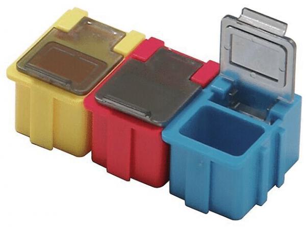 Das Bild zeigt drei kleine, bunte Behälter. Von links nach rechts sind sie gelb, rot und blau. Der gelbe und rote Behälter haben einen flachen Deckel, der blaue ist geöffnet und zeigt ein offenes Fach.