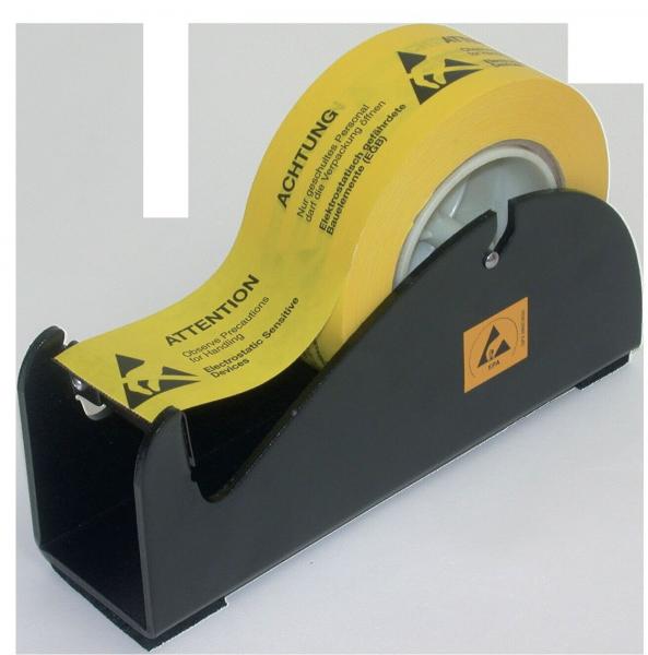 In the picture is a black tape dispenser with a yellow roll of tape. The tape carries warning notices in German, e.g., "Achtung" and "ATTENTION".