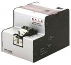 Preview: The image shows an automatic screw feeder. It has a compact, rectangular shape with a bright top and a darker front. Various buttons and an opening are visible on the sides.