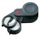 Preview: The image shows a black magnifying glass with two lenses: one larger, round lens and a smaller one. It features a red button and a compact, foldable design.