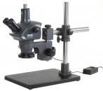 Preview: The image shows a microscope on a stable, rectangular base. It has two eyepieces and a flexible arm for adjusting the height. To the left, there is a control unit.