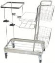 Preview: The image shows a silver serving cart with four wheels. It has multiple shelves in the form of a wire basket and a flat surface on top. The frame is made of metal.