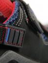 Preview: The image shows a close-up of a shoe. The shoe is black with blue and red accents. A buckle and stitching are visible, the fabric appears sturdy and sporty.