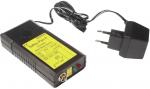 Preview: The image shows a black device with yellow lettering, two buttons, and a connector. Next to it lies a black plug with two prongs and a short cable.