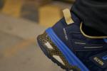 Preview: The image displays a close-up view of a sports shoe in blue and black. The shoe features yellow accents and a textured sole that provides good traction.