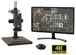 Preview: Das Bild zeigt ein Mikroskop mit einem Monitor. Der Monitor zeigt eine Leiterplatte im Detail an. Rechts unten steht 