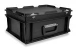 Preview: Das Bild zeigt eine schwarze, robuste Aufbewahrungsbox mit einem flachen Deckel und seitlichen Griffen. Die Box hat eine rechteckige Form und ist aus Kunststoff gefertigt.