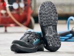 Preview: Das Bild zeigt ein Paar schwarze Sicherheitsschuhe mit rutschfester Sohle. Die Schuhe haben eine blaue Innenverkleidung und sind auf einem grauen Untergrund platziert.