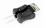 Preview: The image shows a black adapter with a USB plug at one end and two pins at the other end. The adapter has a rubberized, textured surface for better grip.