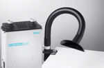 Preview: The image displays a smoke extraction device with a silver casing and a flexible, black hose aimed at a work surface.