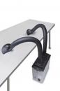 Preview: The image shows a device with a rectangular casing, from which two flexible hoses protrude. The hoses are black and slightly curved, running across a table.