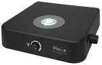 Preview: The image displays a square, black device with a circular lens in the center. On the front, there is a dial and a control light. It is a vision aid device.