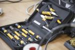 Preview: The image shows a tool bag. Inside, there are several screwdrivers and a small pair of pliers, all with black handles and yellow accents. The bag is closed and flat.