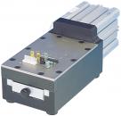 Preview: The image shows a compact device with a rectangular casing. It has a metal surface, cooling fins on the top, and a front with a slider and multiple ports.