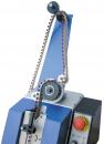 Preview: The image shows a machine with a blue casing. A movable arm with a black button and a chain leads to a large wheel. To the right, there is a red emergency stop button.
