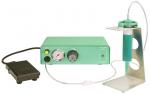 Preview: The image shows a medical device in soft green tones. It has a pressure gauge and a rotary knob. Next to the device, there is a foot pedal and a container on a metal stand.