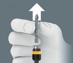Preview: A gray background, on which a hand is holding a screwdriver with a magnetic attachment. Above the hand, an arrow points upward, indicating an action or direction.