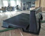 Preview: The image shows a black, rectangular object with a wavy surface and vertical grooves. It appears to be standing on a transparent base, surrounded by blurry boxes.